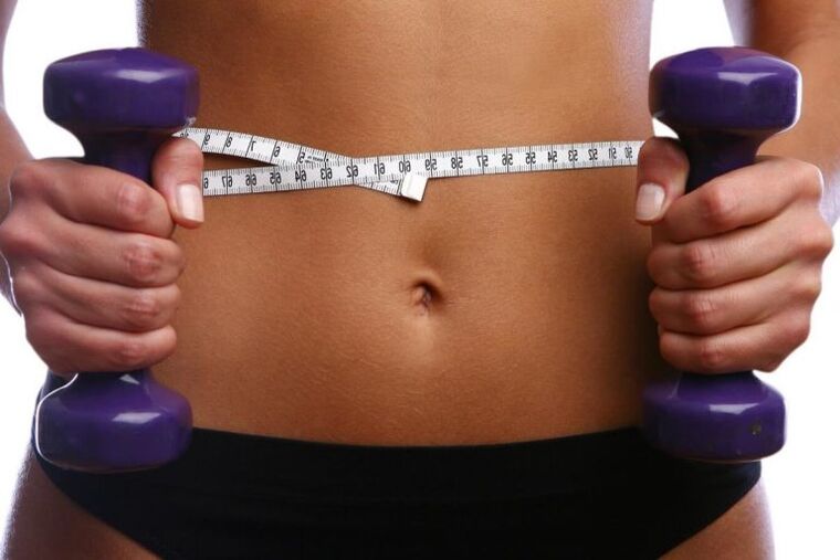 Fitness dumbbells in the hands of a girl in shape